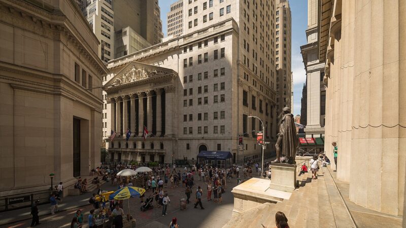 New York Stock Exchange building on Wall Street with crowds below